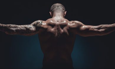 muscular male Bodybuilder posing in studio over black